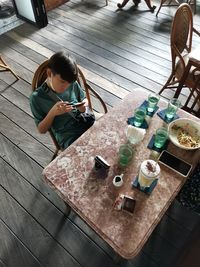 High angle view of boy sitting on table