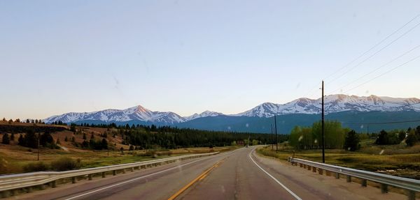 Road by mountains against clear sky