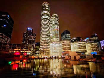 Illuminated buildings against sky at night