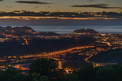 High angle view of illuminated cityscape against sky during sunset