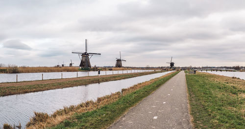 Road by canal against sky