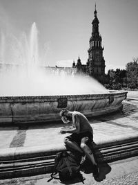 Man splashing water against sky