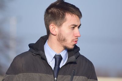 Close-up of young man standing against sky