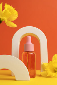 Close-up of beauty products against yellow background