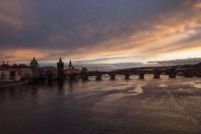 Bridge over river against sky during sunset