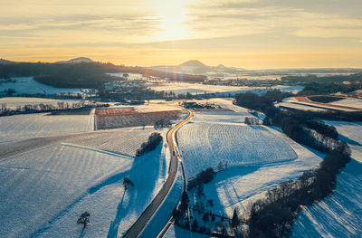 Aerial view of winding driving road during sunset in winter landscape