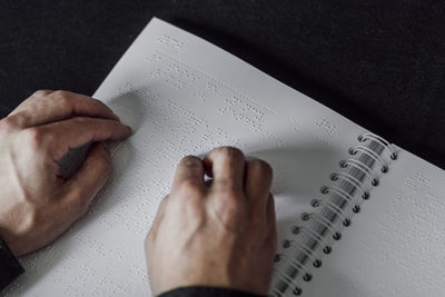 High angle view of human hand on book