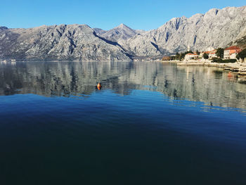 Scenic view of lake and mountains against blue sky