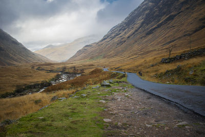 Road leading towards mountains against sky