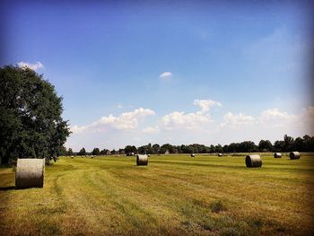 Hay bales on field against sky