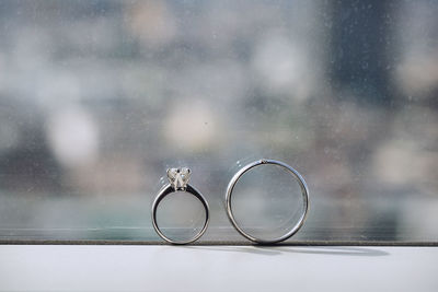 Close-up of wedding rings on glass window