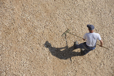 Rear view of man walking on sand at beach