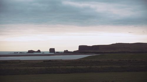 Scenic view of landscape against cloudy sky