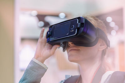 Mid adult woman using virtual reality at home