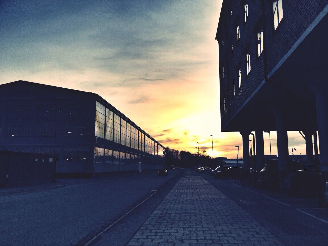 architecture, built structure, sunset, building exterior, sky, the way forward, transportation, cloud - sky, diminishing perspective, city, orange color, vanishing point, bridge - man made structure, connection, road, cloud, outdoors, street, long, no people