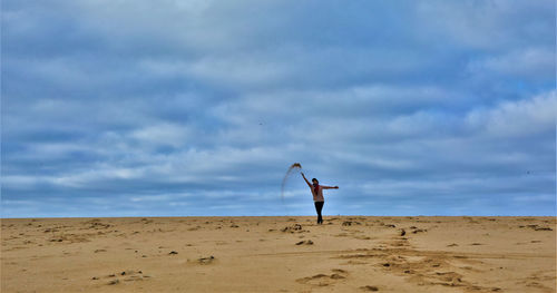 Woman standing on beach against sky