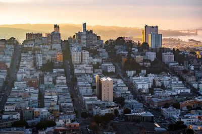 Aerial view of buildings in city during sunset