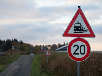 Close-up of road sign against sky