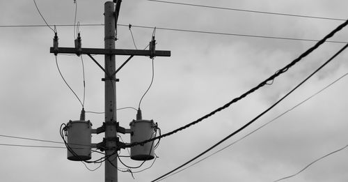 Low angle view of electricity pylon against sky