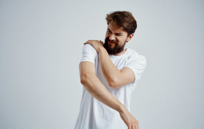 Young man looking away against white background