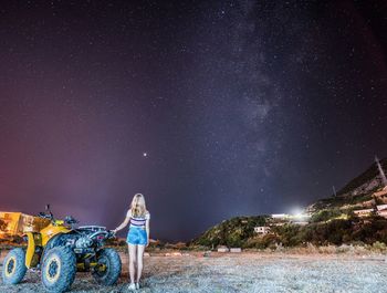 Rear view of man standing against sky at night