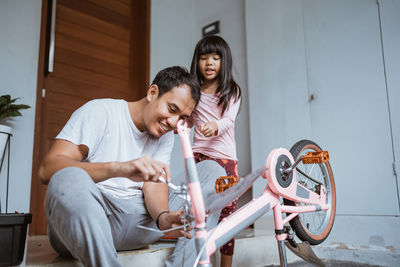 Father repairing bicycle outdoors