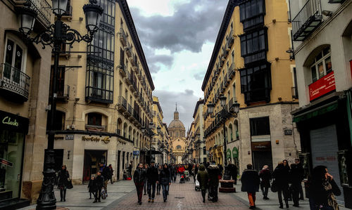 People walking on street amidst buildings in city