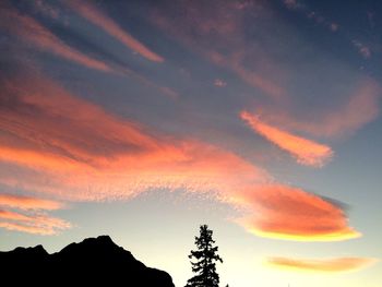 Scenic view of mountains against cloudy sky at sunset