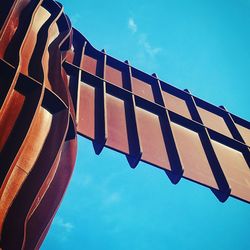 Low angle view of clothes hanging against blue sky