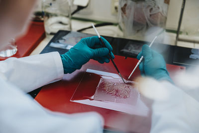 Scientist preparing human brain slide on glass at laboratory