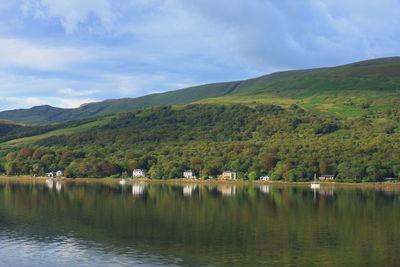 Scenic view of lake by mountains against sky