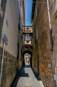 Narrow alleyway with old buildings and traffic sign at the town of orvieto, italy.