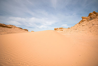 Sand dunes in desert against sky