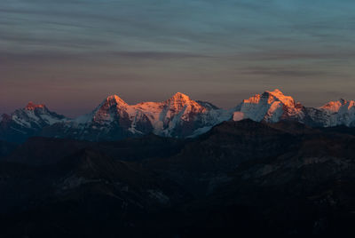 Scenic view of snowcapped mountains against sky during sunset