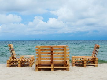 Chairs on beach against sky