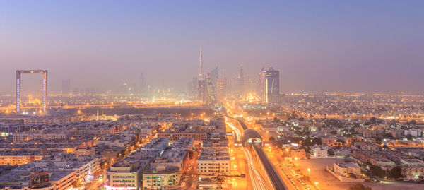 Illuminated cityscape against sky at night