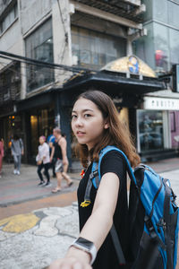 Portrait of young woman in city