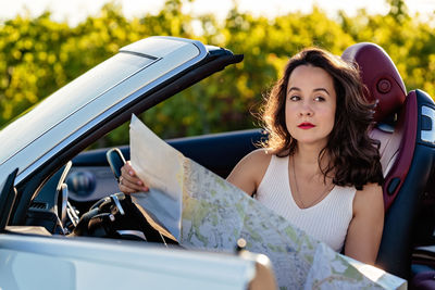 Portrait of young woman sitting in car