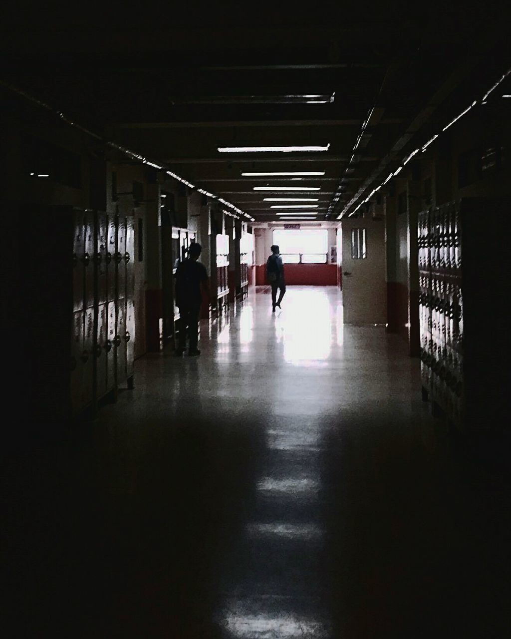 MAN IN ILLUMINATED UNDERGROUND CORRIDOR