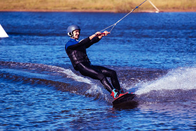 Young man kiteboarding on sea