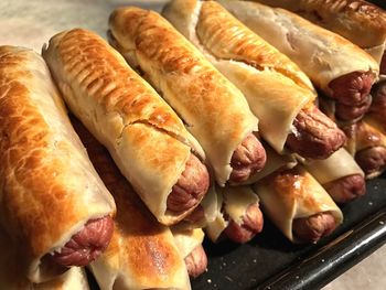 High angle view of sausage rolls on baking sheet on table