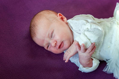 High angle view of cute baby boy lying on bed at home