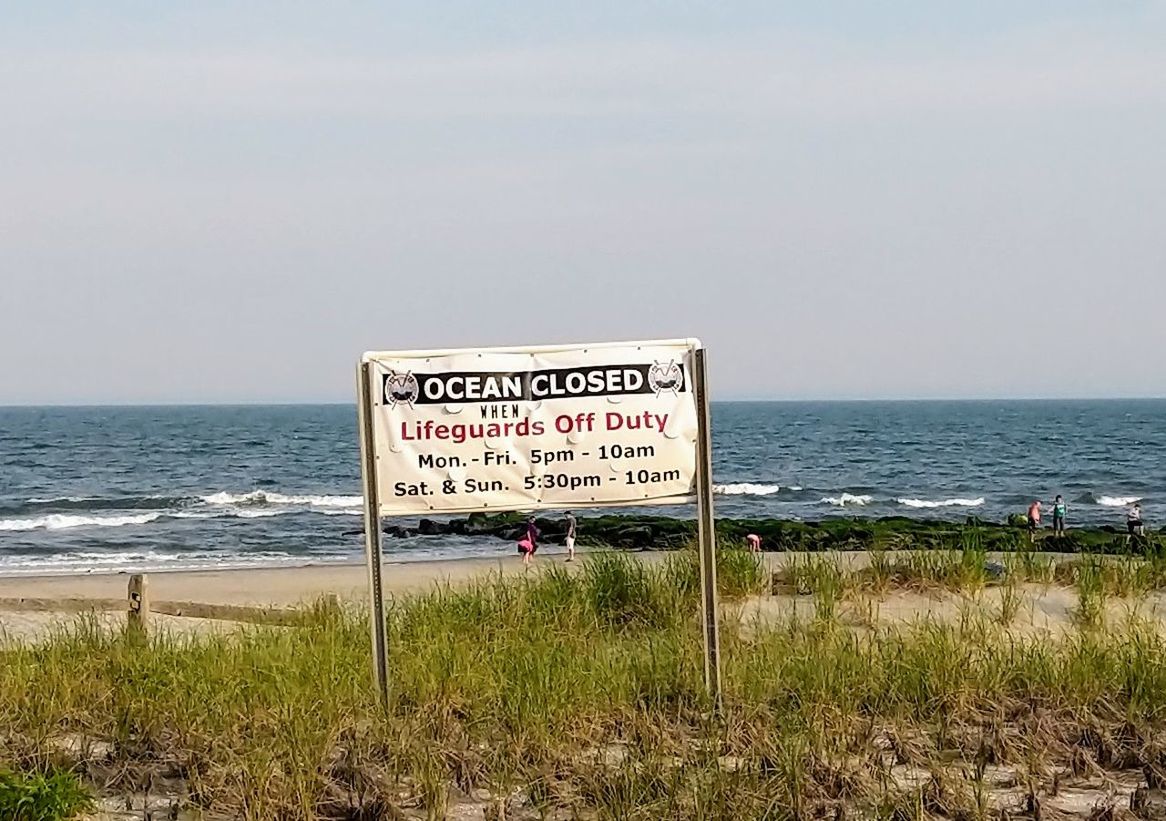 water, sea, horizon over water, sky, communication, horizon, land, beach, nature, sign, text, information, western script, grass, beauty in nature, scenics - nature, information sign, plant, day, no people, outdoors