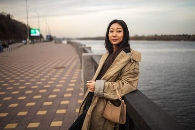 Asian girl standing on bridge in winter city