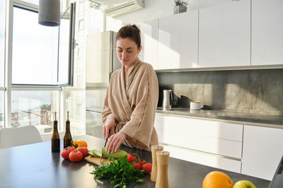Portrait of young woman standing in kitchen