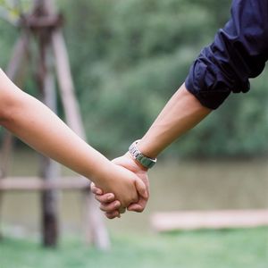 Midsection of couple holding hands