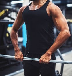 Midsection of man exercising at gym