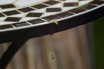 Close-up of raindrops falling on metal