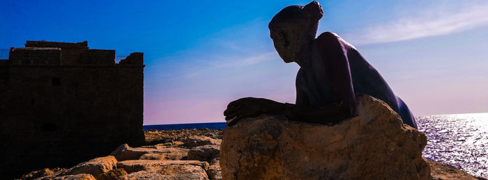 Panoramic view of sea and rocks against blue sky