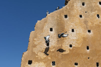 Low angle view of bell tower against blue sky